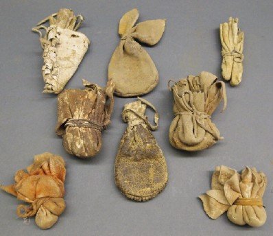 8 Native American Hide Bags: A Group of Eight Native American Bags. Hide bags with hide ties, most likely for medicine. Wear and age evident to each, several with small holes, and one has pulled away at the seam. From 3 1/2" to 5