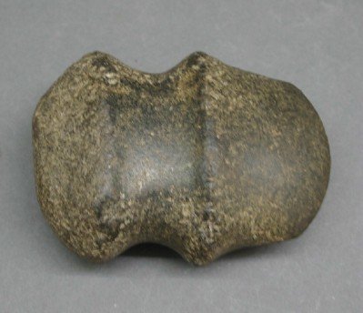 Native American Stone Axe Head: A Native American Full Groove Stone Axe Head. Consisting of carved stone, with a point and blunt end and a Full groove for attachment. Some wear and nicks noted . 4 1/2" long. ESTIMATE $100-150