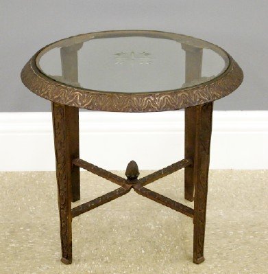 Art Deco Side Table: An Art Deco Era Patinated Cast Iron Table. Round table with inset cut and etched glass top that is decorated with floral and leaf motifs, a curvilinear pattern about the apron, Four tapered legs with 