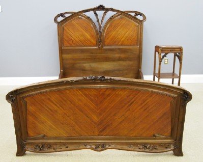 Majorelle Art Nouveau Bed: A turn of the Century Majorelle "Clematis" Pattern Art Nouveau Bed. Mahogany and figured mahogany with arched crests, Shaped panels, and carved floral designs. Original finish with some wear and minor