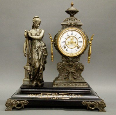 Ansonia "Music" Clock: A Turn of the Century Ansonia "Music" Figural Mantle Clock. Eight day clock with Half-Hour Gong Strike, open escapement, and enameled Porcelain dial. Cast metal case and Figure of a woman, shown stand