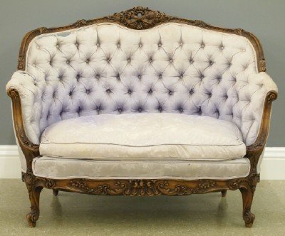 Louis XV Style Settee: An Early 20th Century Louis XV Style Carved Walnut Settee. Shaped crest with carved floral design, scrolled arms, shaped skirt on short cabriole legs. Original finish with some wear, upholstery is poo