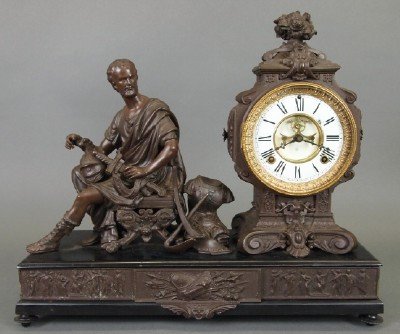 Ansonia "Cincinnatus" Clock: A Late 19th Century Ansonia "Cincinnatus" Figural Clock. Eight day time and strike movement with open escapement and enameled Porcelain dial. Patinated metal case and Figure, shown seated, atop an Ebo