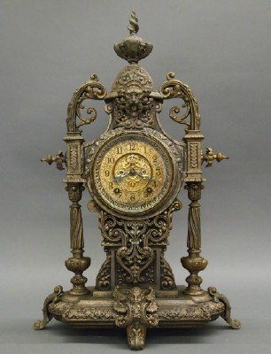 Ansonia "Imperial" Clock: A Turn of the Century Ansonia "Imperial" Mantle Clock. Eight day time and strike movement with open escapement and gilded Metal dial. Having an elaborate cast metal case with motifs of scrolls, contor