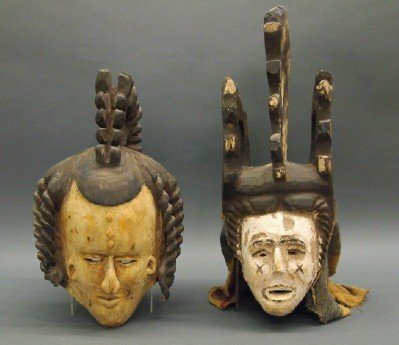 2 African Carved Wood Masks: Two African Carved and Polychrome Wood Masks, possibly Igbo. Including One with elaborate headdress, painted white face with a black "X" under each eye, and an attached polychrome cloth covering at th