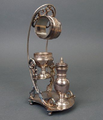 Pairpoint Silver Plate Combination Set: A 19th Century Pairpoint Silver Plate Combination Set. Consisting of a Salt Dish, a Pepper shaker, and a Napkin ring all on a stand with scrolling motifs. Stamped at the underside with maker's mark an