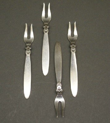 Georg Jensen Hors D'Oeuvres Forks: A Set of Four George Jensen & Wendel A/S Hors D'Oeuvres Forks. Each in the "Cactus" pattern and stamped "Sterling Denmark Georg Jensen & Wendel A/S". Minor wear to each. 3 1/2" long. Totaling 1.30 tro
