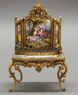 Austrian Miniature Bonheur du jour: A Turn of the Century Austrian Miniature Bonheur du jour. Having an Ormolu frame and inset enameled panels that are decorated with Courting scenes. Unmarked. Minor wear. 5 1/4" high. ESTIMATE $300-500