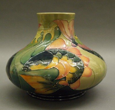 Moorcroft/Tuffin "Carp" Pottery Vase: A Moorcroft "Carp" Pottery Vase, c. 1995. Originally designed by Sally Tuffin, this unusual vase consists of an incised repetitive pattern of colorful Carp, shown in motion, against a two-tone green g