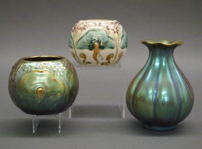 3 Zsolnay Vases: A Group of Three Zsolnay Vases. Including Two iridescent and One with purple flower and green foliate motif. All with maker's trademark logo. Crazing to the iridescent pieces. Up to 4 3/4" high. ESTIM