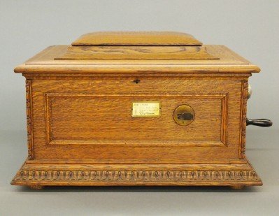 Model #11 Regina Disc Player: An early 1900's "Regina Model #1" one coin operated 15 1/2" disc player, serial number 39135. Carved oak case, includes 13 discs. Some rust to a number of discs and minor wear overall. 23 1/2" x 20 1/