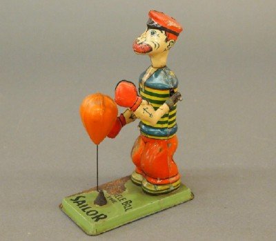 J. Chein & Co. Boxer Toy: A 1930's "J. Chein & Co. Barnacle Bill the Sailor and Punching Bag" tin litho toy, with winding key. Some heavy rust and paint loss to the right leg and base and minor wear overall. 7 1/2" overall. ES