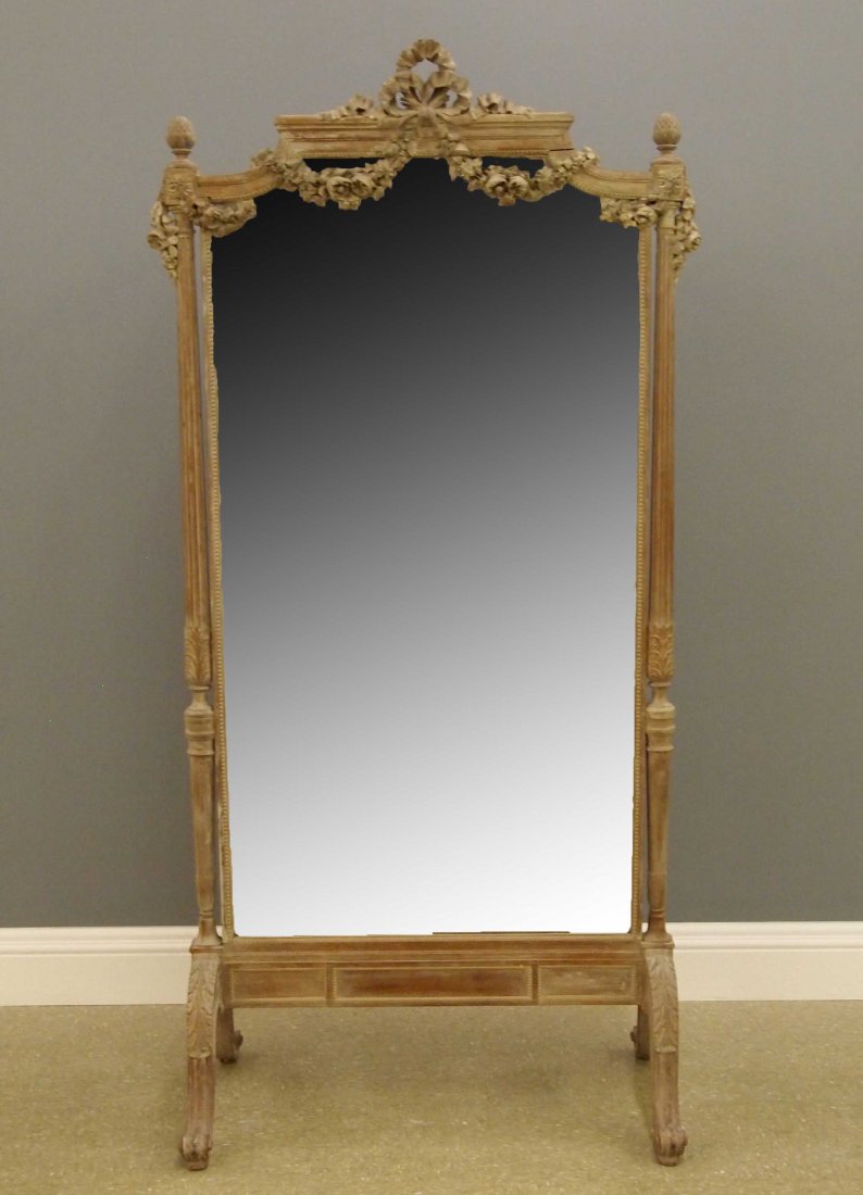 French Dressing mirror: A late 19th century French Louis XVI Style Dressing mirror. Shaped crest with hand carved ribbons and floral swags over two turned supports with fluted detail flank a shaped beveled mirror, the whole 