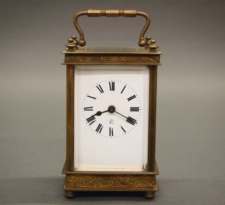 French Carriage clock: An early 20th century French Carriage clock. 8-day time only movement in a Brass case with embossed detail and beveled glasses. Some wear. 6" high overall. ESTIMATE $100-200