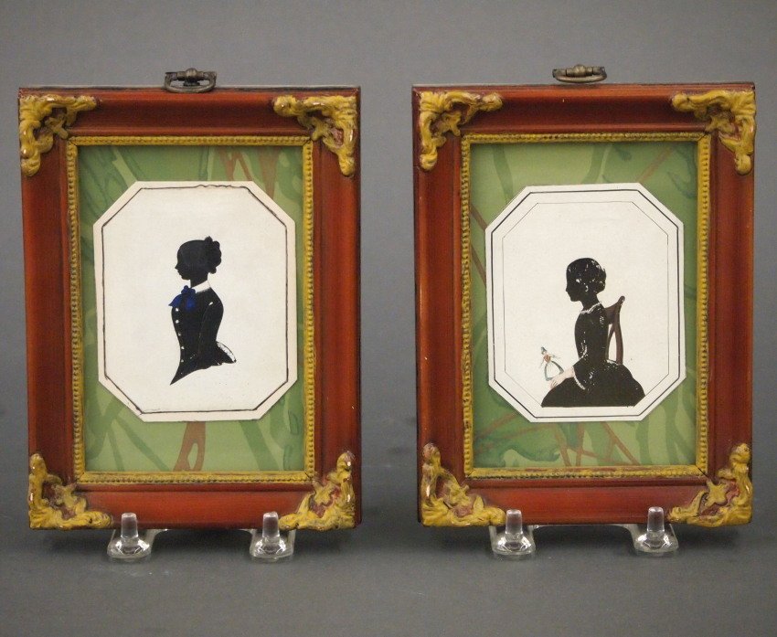 Pr Silhouettes: A pair of 19th century painted silhouettes. Profiles of a two girls, one holding a doll in Black with Multi-color detail. Minor craquelure. Each image 3 1/4 x 4 1/2, in modern frames 4 3/4 x 6" overal