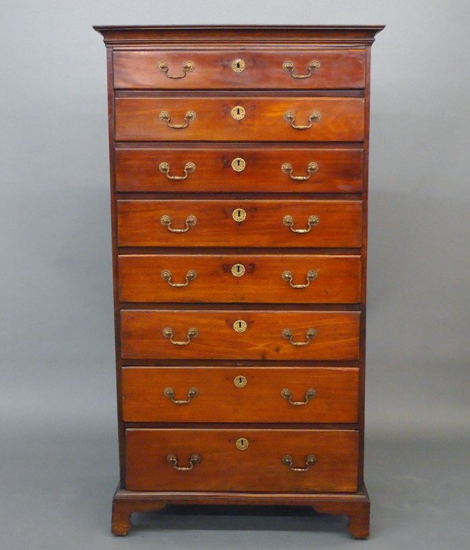 Irish Mahogany tall chest: A 19th century Irish Mahogany tall chest of drawers. A beveled cornice above eight drawers of graduated size, raised on bracket feet. Older refinishing with wear, and some older repair, replaced hardw
