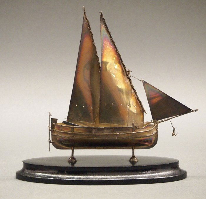 Maltese Silver sailboat: A 20th century Maltese Silver sailboat. Featuring three sails and two detached oars, mounted on a wood base. Hallmarks at the hull indicate .917 fineness. Minor wear. 8 x 8 1/4" high overall. ESTIMATE