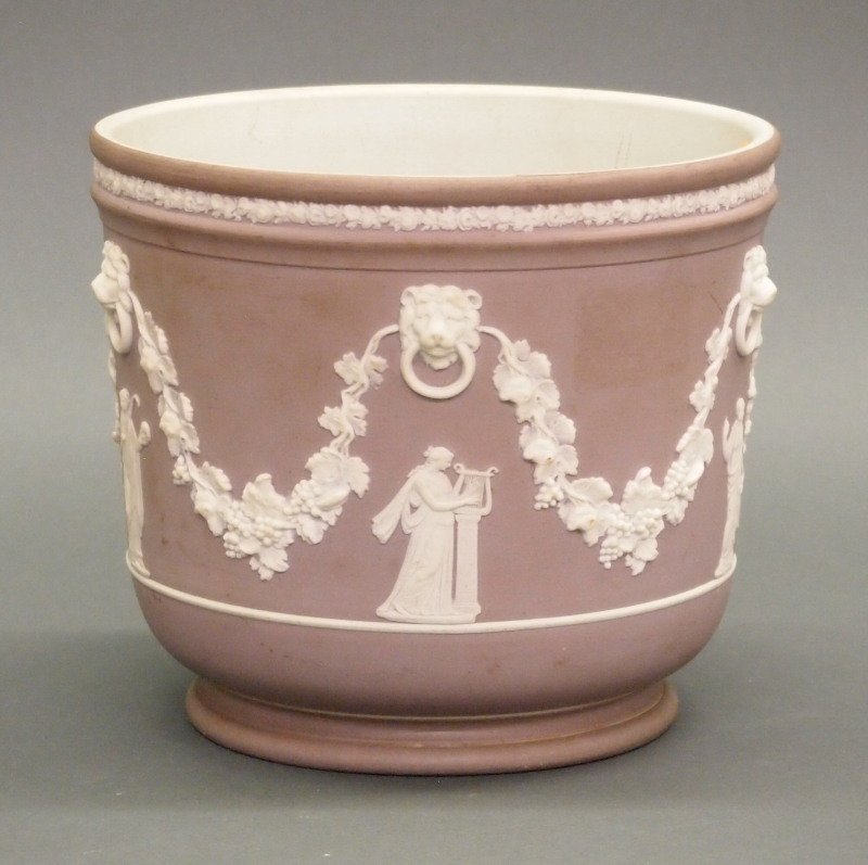 Wedgwood Jasperware jardinière: A 19th century Wedgwood Lilac Jasperware jardinière. Round, decorated in white cameo relief with classical muses beneath lion-mask-and-rings, within grapevine swags on a lilac ground. Impressed "Wedg
