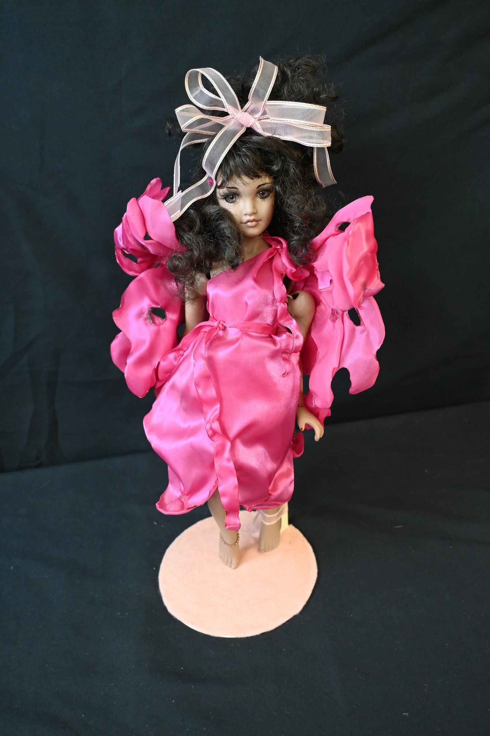 Collectible Porcelain Fairy/Butterfly Doll in Hot Pink Satin Dress with Wings & Display Stand: This beautiful, vintage-style doll features a porcelain face, lower arms, and lower legs. It is dressed in a vibrant, ruffled hot pink satin/silk dress with matching fabric butterfly or fairy wings at