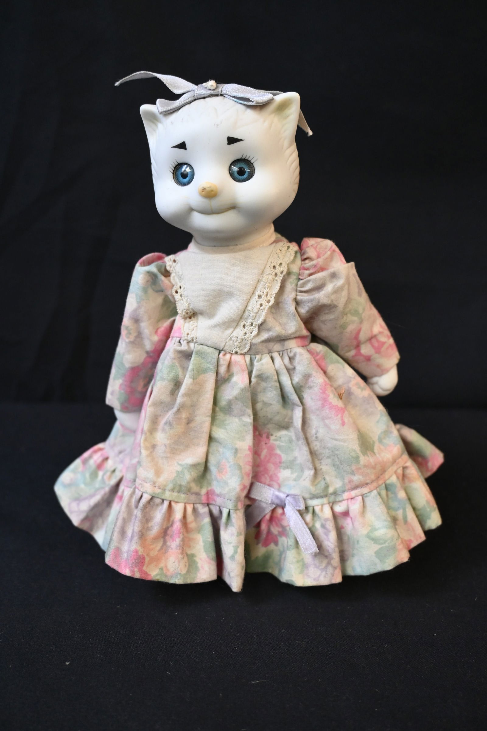 Dolly Dingle Porcelain Cat Doll – Designed by Bette Ball & Karen Kennedy for Goebel: This Dolly Dingle porcelain cat doll is part of a collectible series produced by Goebel and designed by Bette Ball and Karen Kennedy. Crafted with a porcelain head, hands, and feet, paired with a soft