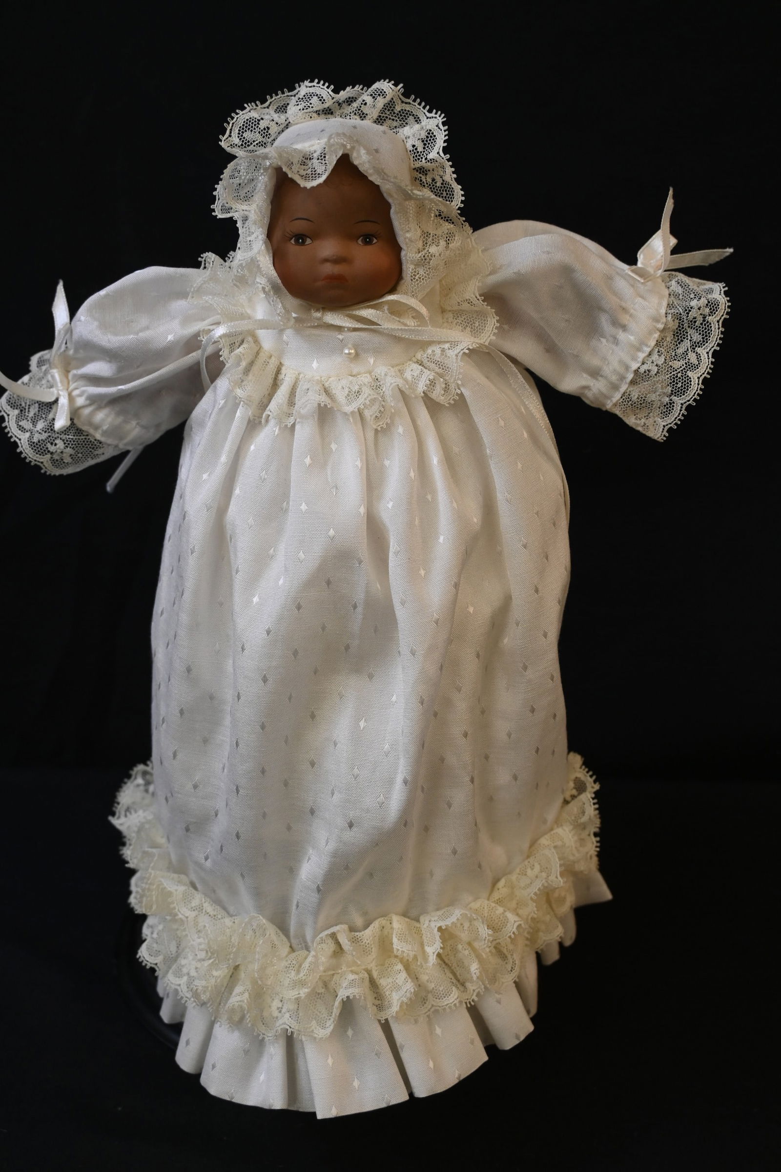 Vintage African American Porcelain Baby Doll – White Christening Gown & Bonnet: This vintage African American collectible baby doll features a porcelain (or bisque) head, hands, and feet with a soft cloth body, characteristic of high-quality collectible dolls.Key Features:Materia