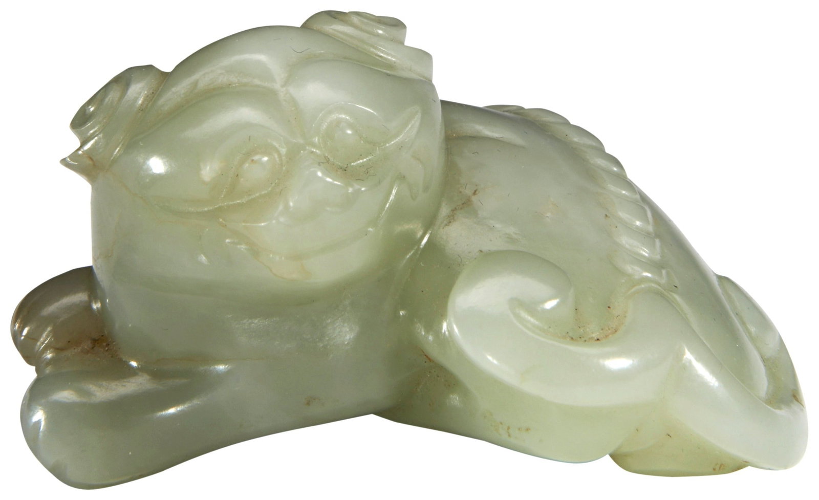 A CARVED CELADON JADE BUDDHIST LION QING DYNASTY, 19TH CENTURY modelled recumbent with its head (1 of 3)