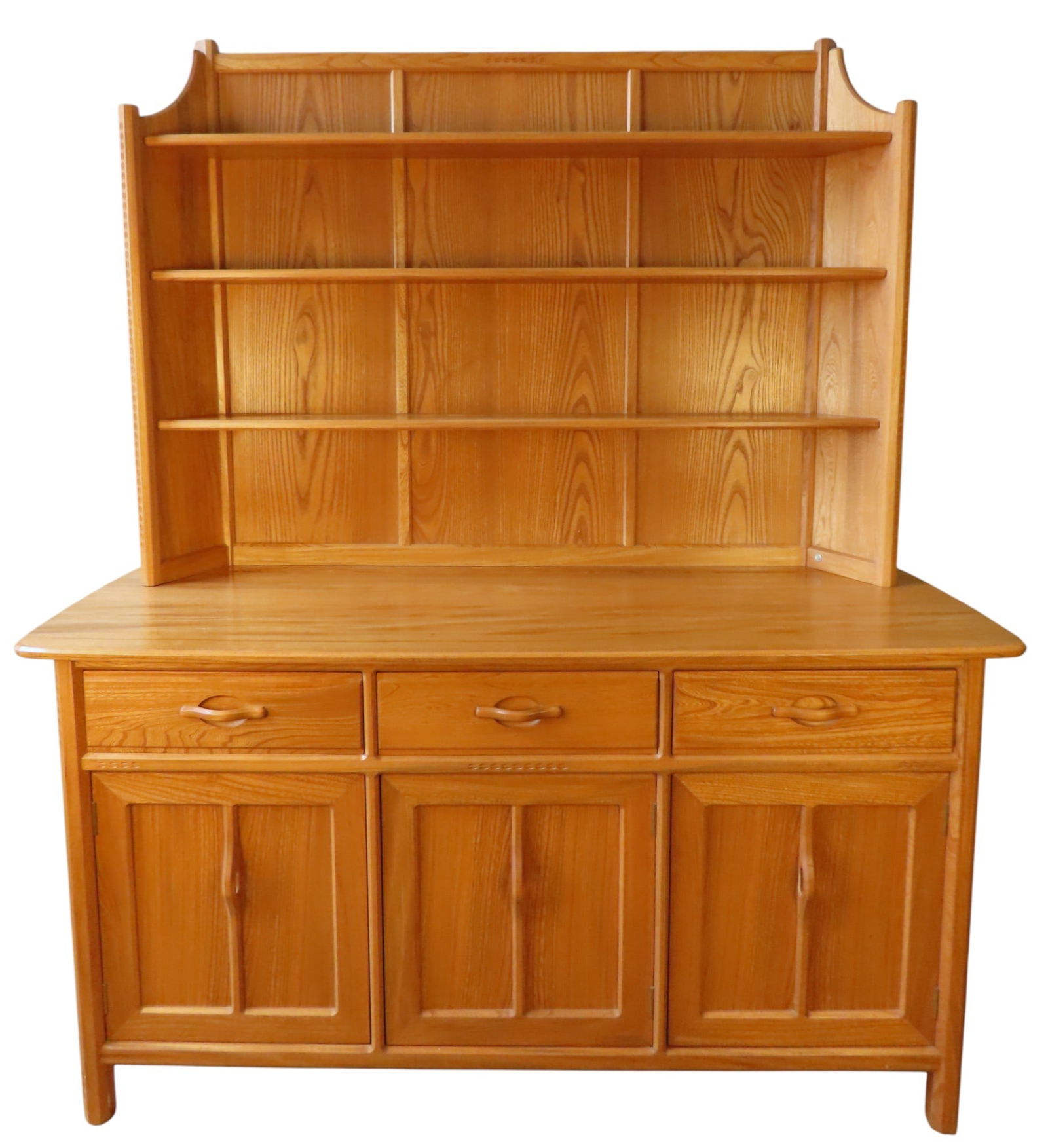 AN ERCOL LIGHT ELM DRESSER a three-tier plate rack sat atop a dresser base comprised of three: AN ERCOL LIGHT ELM DRESSER a three-tier plate rack sat atop a dresser base comprised of three frieze drawers over three panelled cupboard doors, enclosing interior shelves, bearing makers label